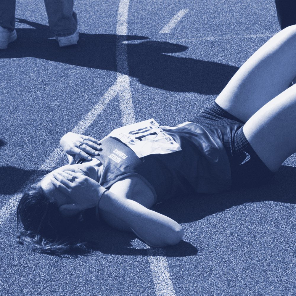 Athlète allongée sur la piste après une course